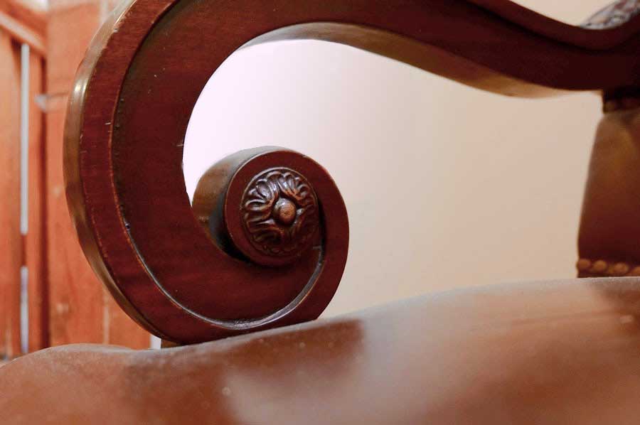 Photo detail of arm of chair featuring spiral form.  DD Swivel Chair, designed by Cass Gilbert for the 1905 Minnesota State Capitol, carved wood, leather